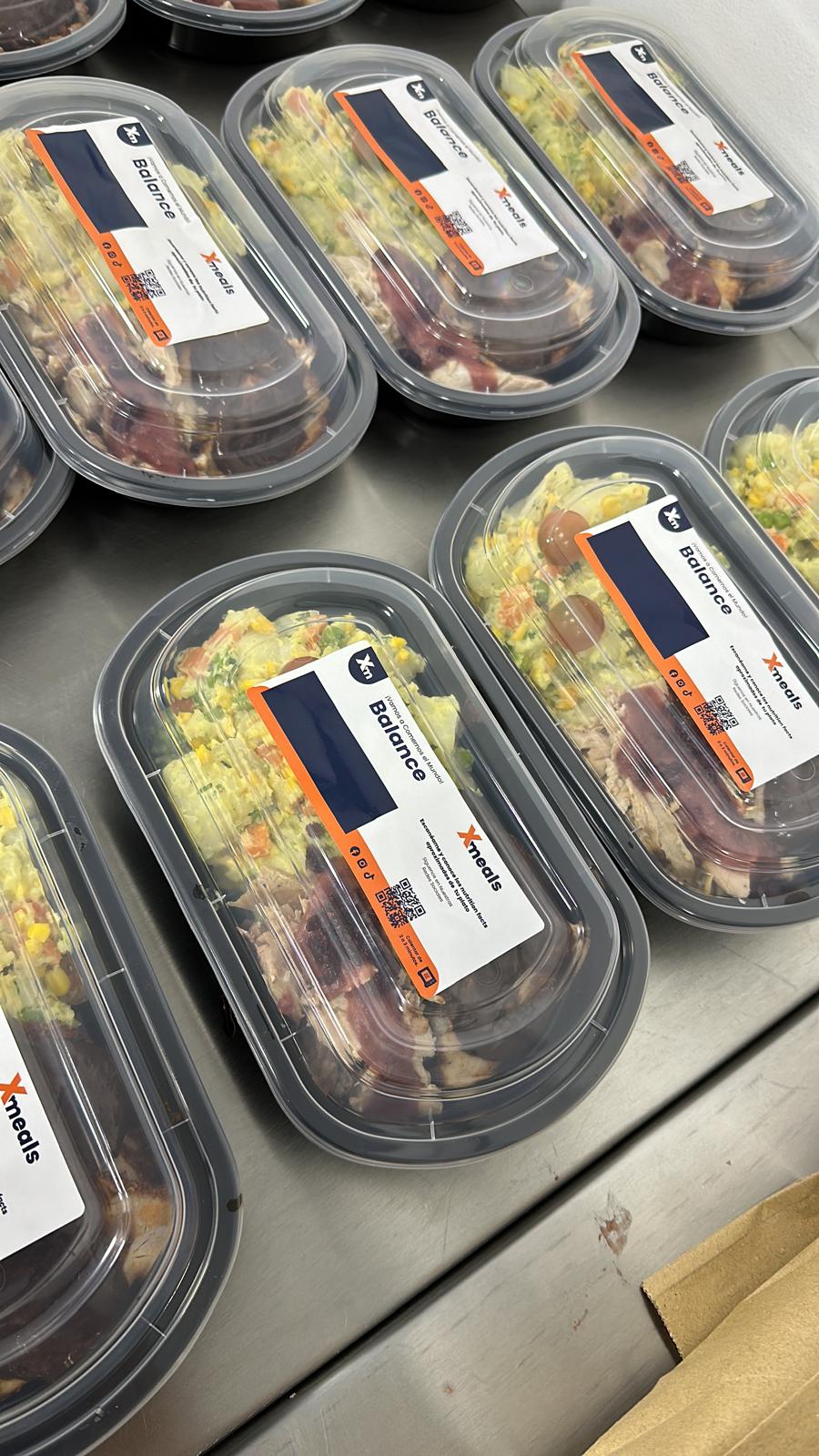 Manos disfrutando un plato premium real de Xmeals